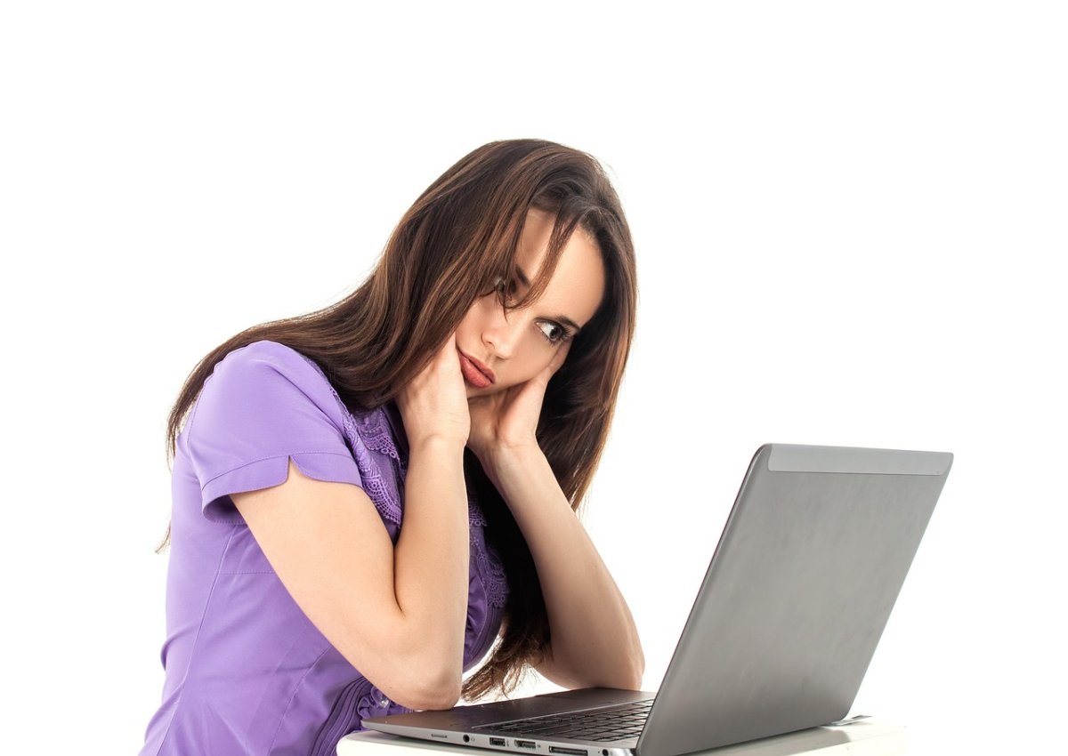 Fatigue mentale et perte de sens au travail – Accompagnement burn-out avec Stressmanager Femme en appui sur ses mains, regard absent, exprimant la fatigue mentale et le stress professionnel.